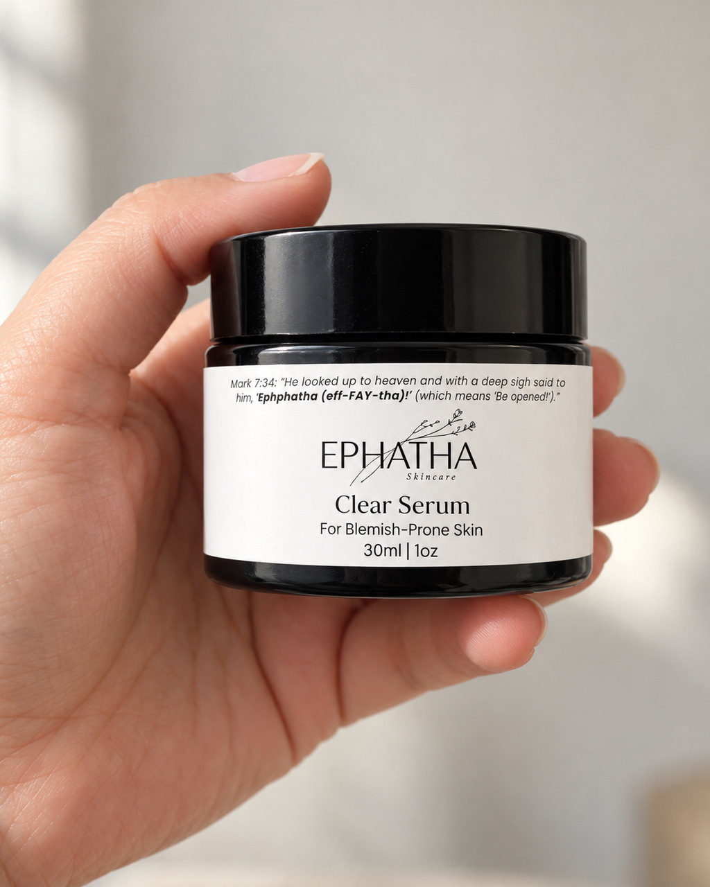 Ephatha Clear Serum 1 oz jar shown in hand for scale
