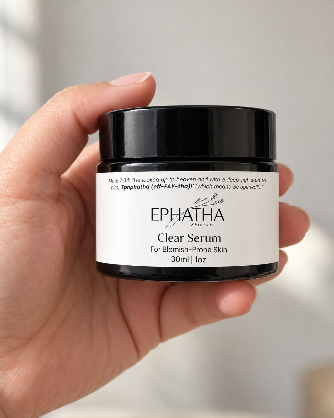 Ephatha Clear Serum 1 oz jar shown in hand for scale