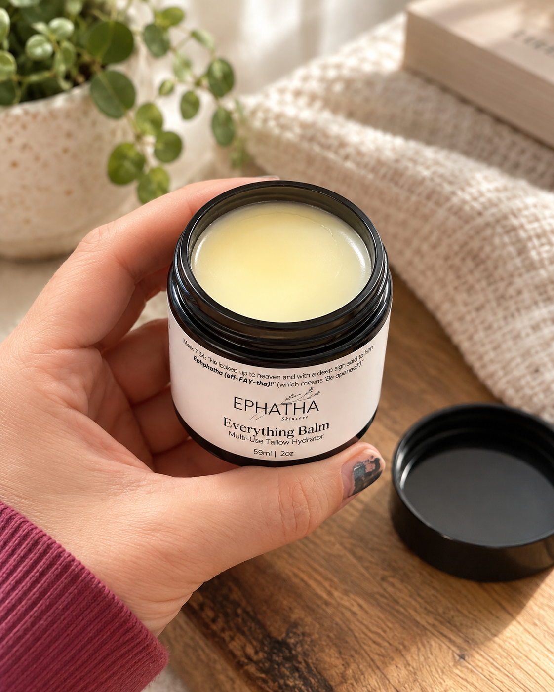 Ephatha Everything Balm open 2 oz jar shown in hand for scale